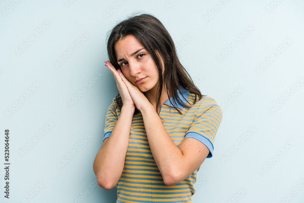 Young caucasian woman isolated on blue background yawning showing a tired gesture covering mouth with hand. Young caucasian woman isolated on blue background yawning showing a tired gesture covering mouth with hand.