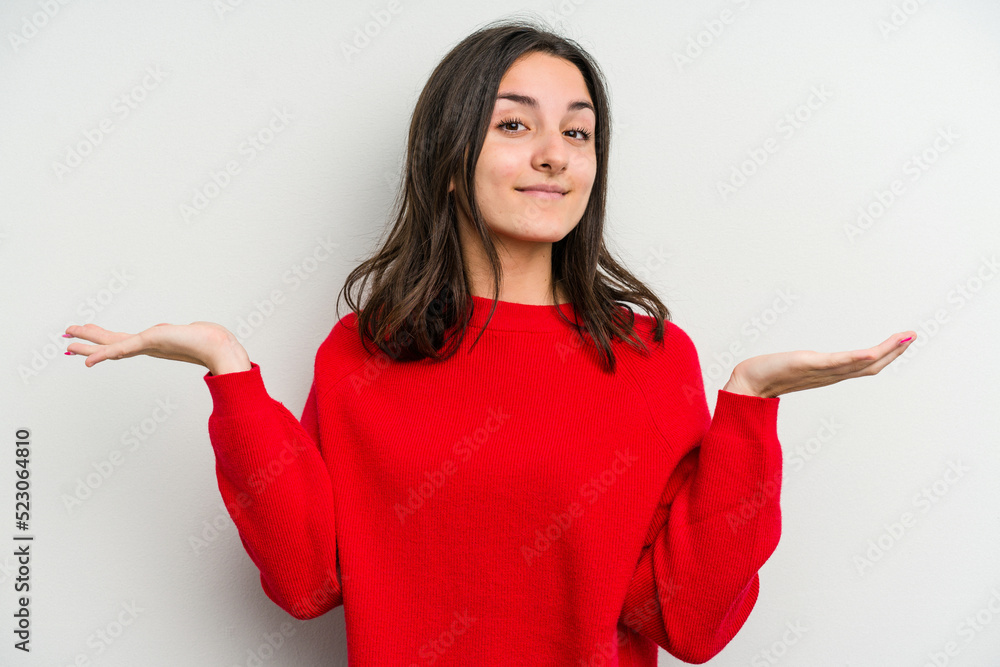 Young caucasian woman isolated on white background makes scale with arms, feels happy and confident. Young caucasian woman isolated on white background makes scale with arms, feels happy and confident.