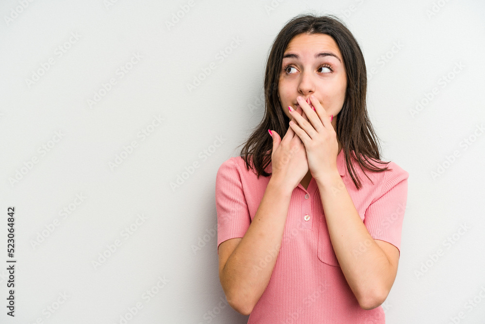 Young caucasian woman isolated on white background thoughtful looking to a copy space covering mouth with hand. Young caucasian woman isolated on white background thoughtful looking to a copy space covering mouth with hand.