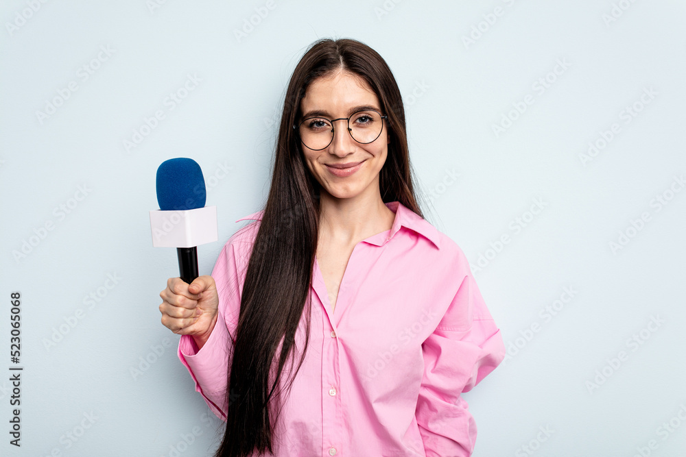 Young caucasian tv presenter woman isolated on blue background happy, smiling and cheerful. Young caucasian tv presenter woman isolated on blue background happy, smiling and cheerful.