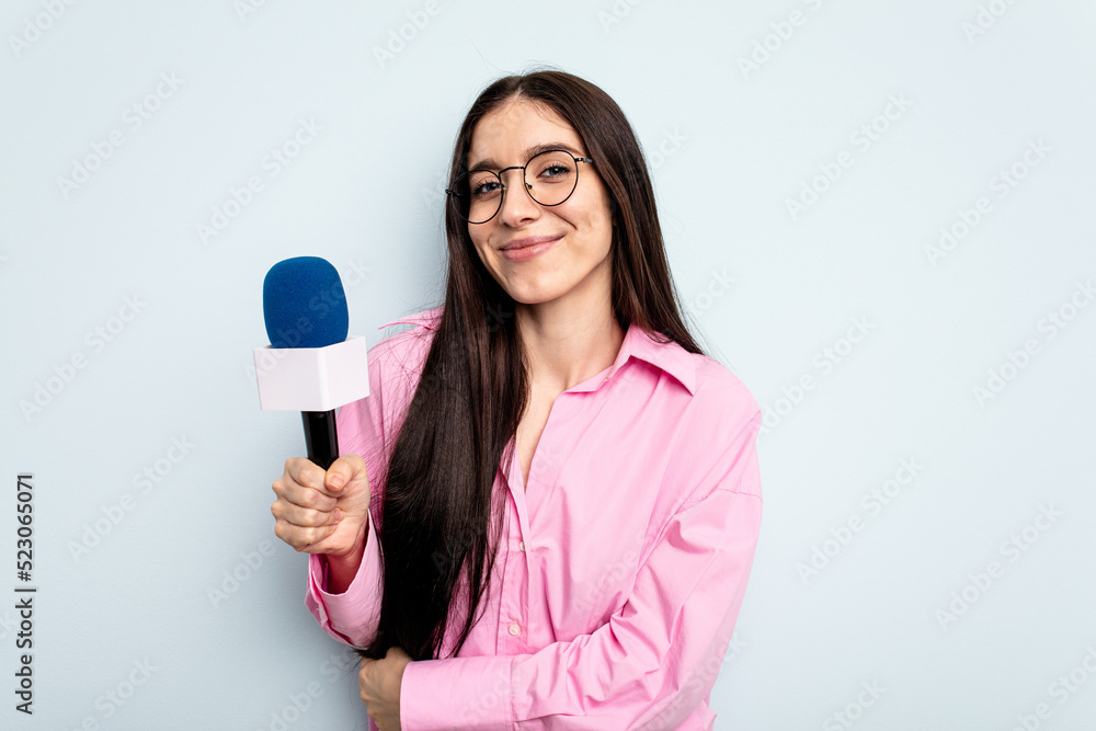 Young caucasian tv presenter woman isolated on blue background laughing and having fun. Young caucasian tv presenter woman isolated on blue background laughing and having fun.