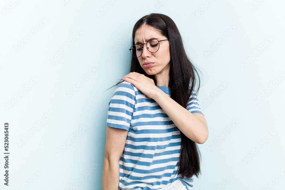 Young caucasian woman isolated on blue background having a shoulder pain. Young caucasian woman isolated on blue background having a shoulder pain.