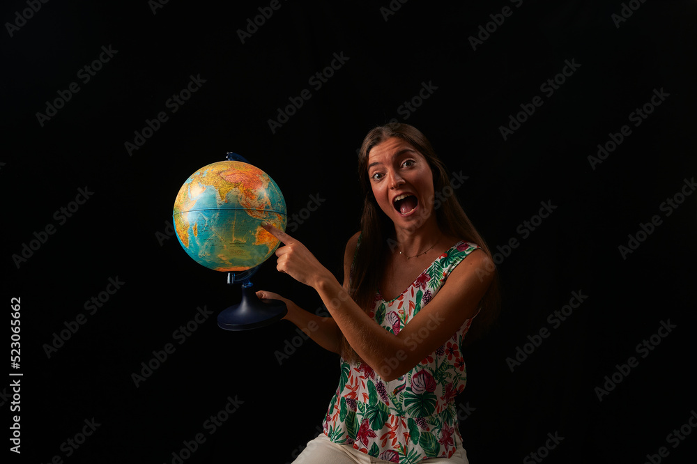 young woman observes the sphere of the world illuminated from within young woman observes the sphere of the world illuminated from within
