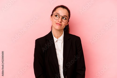 Young business caucasian woman isolated on pink background dreaming of achieving goals and purposes