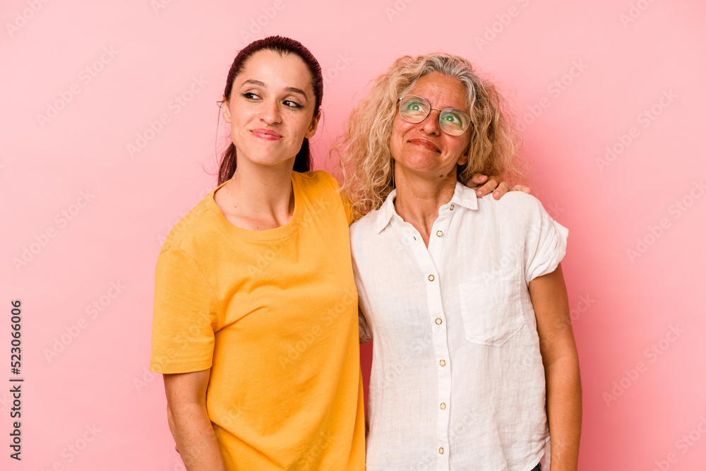 Caucasian mom and daughter isolated on pink background dreaming of achieving goals and purposes Caucasian mom and daughter isolated on pink background dreaming of achieving goals and purposes