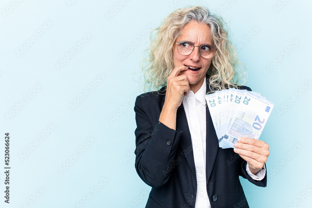 Middle age business caucasian woman holding bank notes isolated on white background relaxed thinking about something looking at a copy space. Middle age business caucasian woman holding bank notes isolated on white background relaxed thinking about something looking at a copy space.