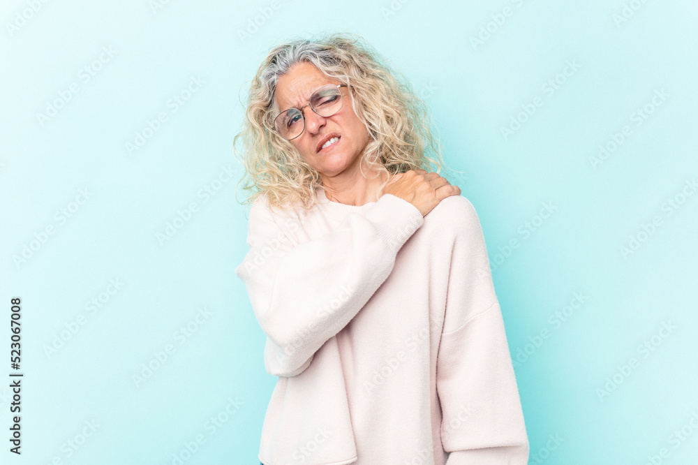 Middle age caucasian woman isolated on blue background having a shoulder pain. Middle age caucasian woman isolated on blue background having a shoulder pain.