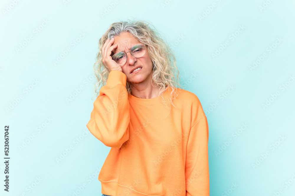 Middle age caucasian woman isolated on blue background tired and very sleepy keeping hand on head. Middle age caucasian woman isolated on blue background tired and very sleepy keeping hand on head.