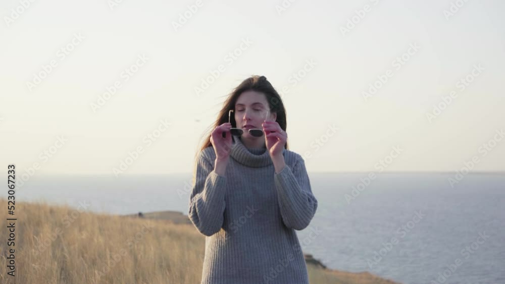Beautiful woman in sweater posing on camera outdoors Beautiful woman in sweater posing on camera outdoors