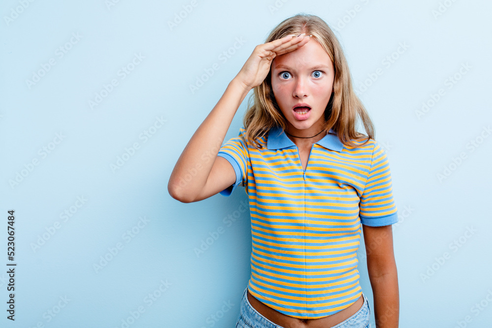 Caucasian teen girl isolated on blue background shouts loud, keeps eyes opened and hands tense. Caucasian teen girl isolated on blue background shouts loud, keeps eyes opened and hands tense.