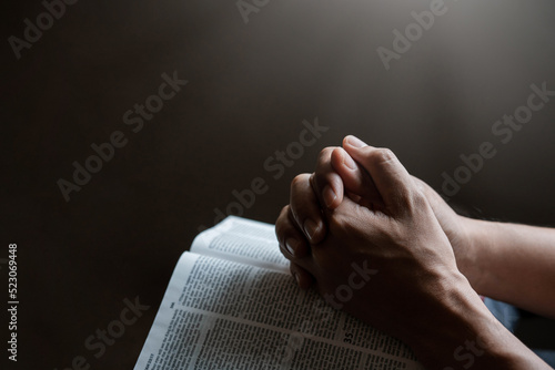 Photography Hands together in prayer to God along with the bible In the Christian concept of faith, spirituality and religion, men pray in the Bible