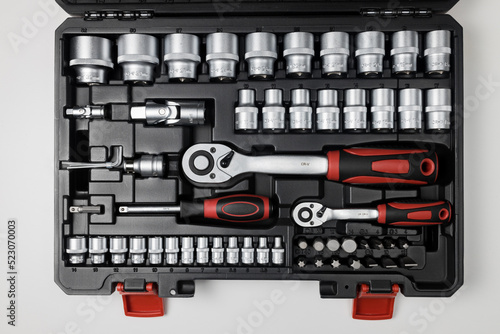  Wrenches of different sizes with different hex heads in a black box on a white table. View from above