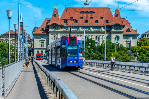 BERN, SWITZERLAND - August 2nd 2022: The blue tram on the Kirchenfeld Bridge over the Aare River. photo