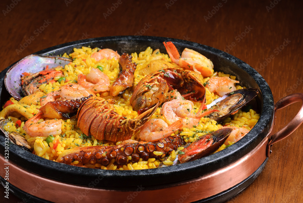 Traditional spanish paella with seafood on wooden table. Spanish cuisine. Traditional spanish paella with seafood on wooden table. Spanish cuisine.