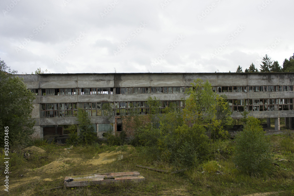 ruined industrial building on stilts with a broken wall of glass fragments. A picture of desolation and destruction. Nature destroys human structures ruined industrial building on stilts with a broken wall of glass fragments. A picture of desolation and destruction. Nature destroys human structures