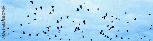 a large flock of black birds flies on a blue background.