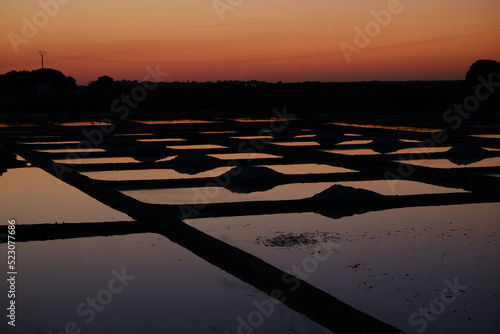 The squared salt marshes of Guérande during the dusk. August 2022, France. (near the Kervalet village) photo