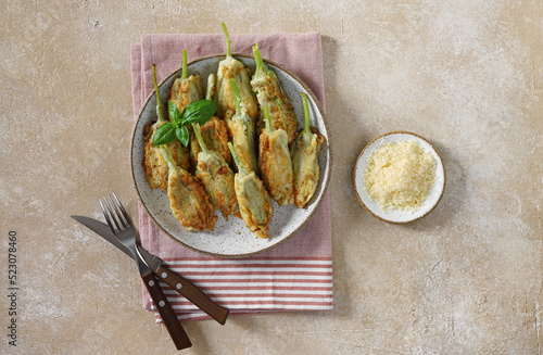 Fried zucchini flowers stuffed with cream cheese served on the plate, tasty Italian dish summer, top view