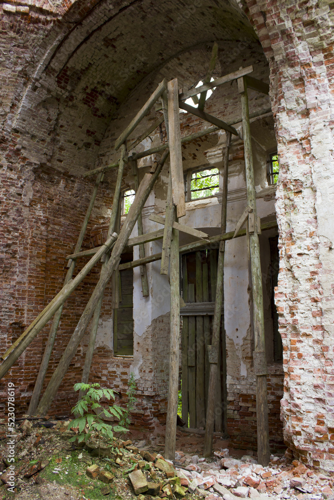 wooden scaffolding and beams in a ruined brick old church. Attempts to restore and prevent the destruction of the structure wooden scaffolding and beams in a ruined brick old church. Attempts to restore and prevent the destruction of the structure