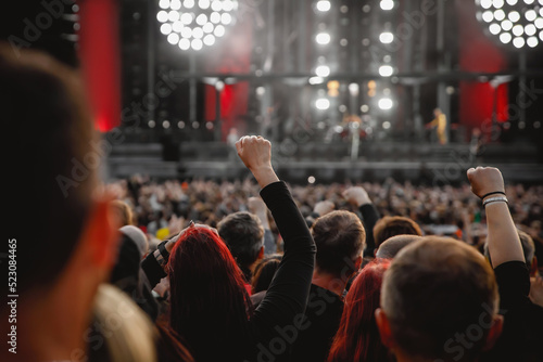 The crowd at a concert. People with raised hands on the dance floor.
