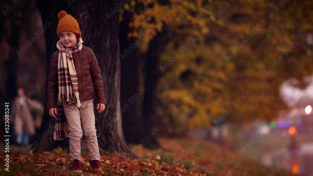 cute kid in warm outfit walking in colorful park on autumn day cute kid in warm outfit walking in colorful park on autumn day