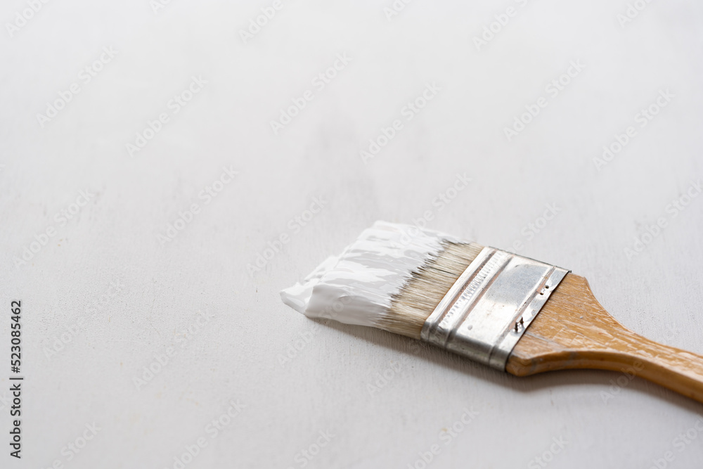 detalle de brocha con pintura blanca sobre madera recién pintada de blanco,  horizontal Stock Photo