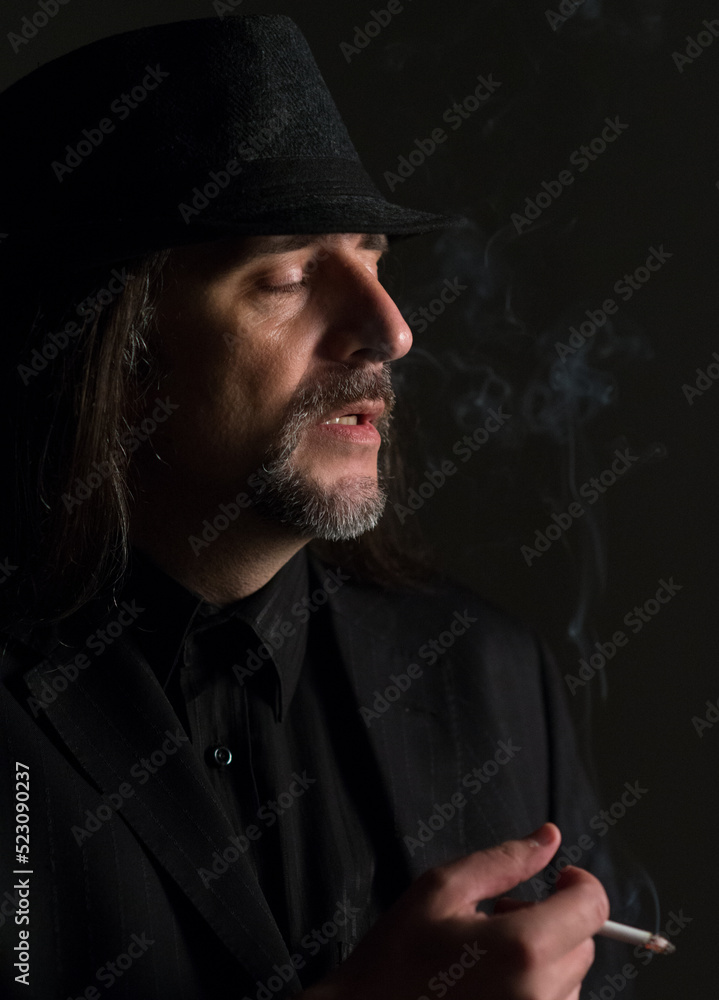 Portrait of middle aged man wearing black clothes and black hat posing in the studio Portrait of middle aged man wearing black clothes and black hat posing in the studio