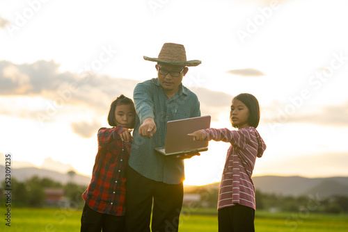 Farmer and kid looking rice field on sunset for learning outdoor from family