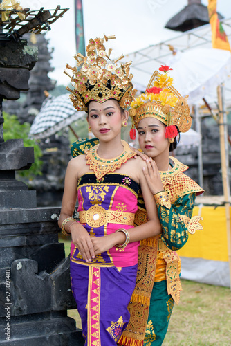 Two beautiful girls in the temple. Dressed in old traditional colorful costume.