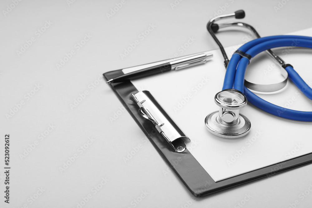 Stethoscope and clipboard on white background, closeup. Space for text Stethoscope and clipboard on white background, closeup. Space for text