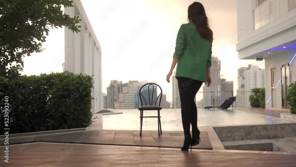 Woman In Green Jacket In High Heels Walking Towards Pool Woman In Green Jacket In High Heels Walking Towards Pool