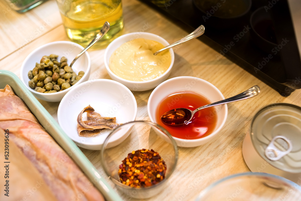 bowls of sauce ingredients: capers, anchovies, mustard, sunflower oil, chili pepper flakes, grape vinegar bowls of sauce ingredients: capers, anchovies, mustard, sunflower oil, chili pepper flakes, grape vinegar