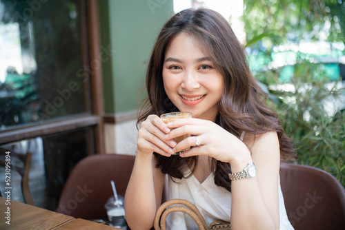 Beautiful smiling asian women sitting in cafe drink coffee shop