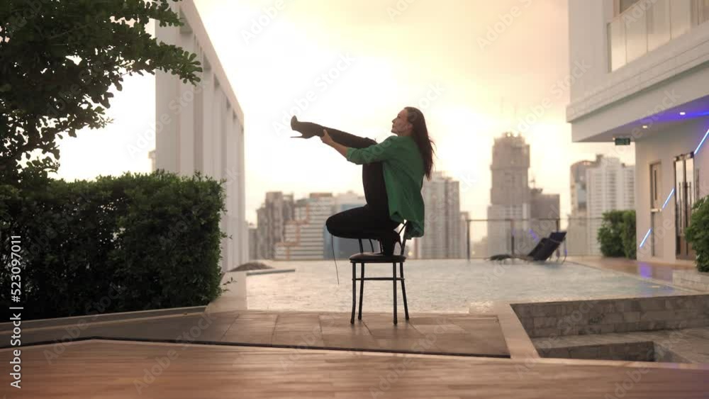 Dancer Crouching On Chair Then Raising Leg At Poolside Dancer Crouching On Chair Then Raising Leg At Poolside