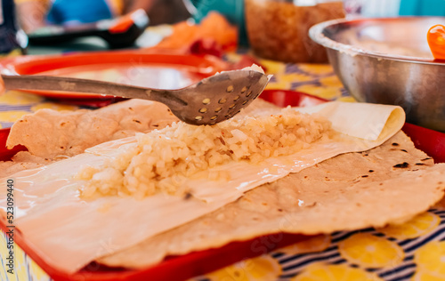 Hands making delicious Nicaraguan Quesillo. Preparation of the Traditional Nicaraguan Quesillo. Central American food the Quesillo, View of the traditional Quesillo with pickled onion photo