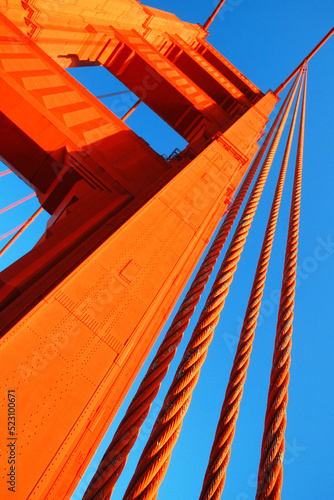 The orange cables of the Golden Gate Bridge in San Francisco extend to the sky and keep the suspension bridge from failing