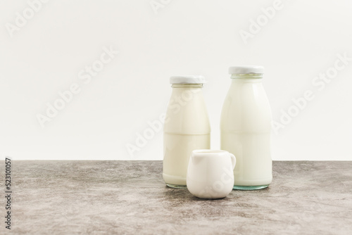 beverage liquid milk white fresh natural in glass bottles on table drink to healthy has protein and calcium for child or toddler, nobody, closeup, white background and copy space on left for content