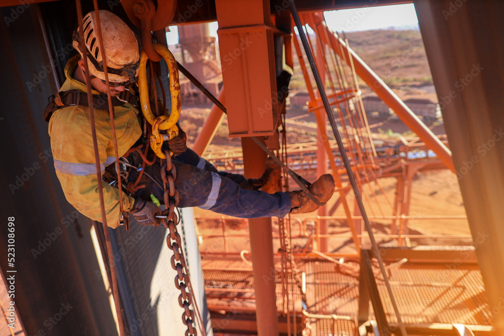Rompy Rigger Rope access rigger wearing fall body safety harness abseiling hanging ...