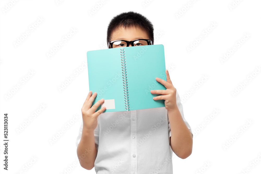 Kid with eyeglasses hiding face behide book and looking at camera Kid with eyeglasses hiding face behide book and looking at camera