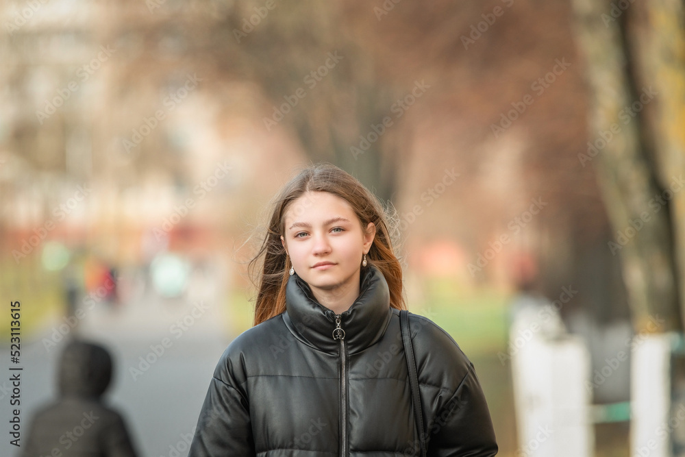 Portrait of a young beautiful fair-haired girl in an autumn jacket close-up. There is artistic noise.