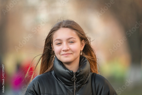 Portrait of a young beautiful fair-haired girl in an autumn jacket close-up. There is artistic noise.