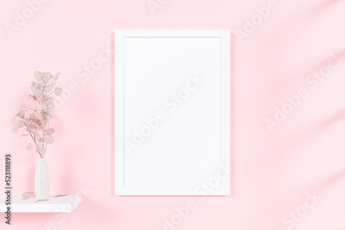 A mockup picture frame with flower vase on pink wall background. 3d rendered illustration.