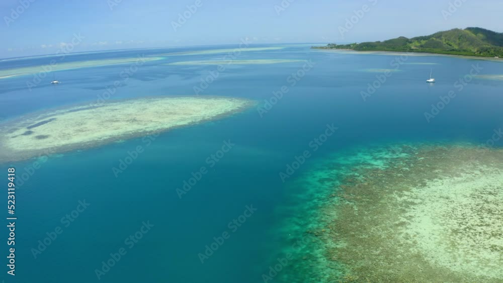 Aerial Panning Shot Of Nautical Vessels Floating On Sea By Island, Drone Flying During Sunny Day - Suva, Fiji Aerial Panning Shot Of Nautical Vessels Floating On Sea By Island, Drone Flying During Sunny Day - Suva, Fiji