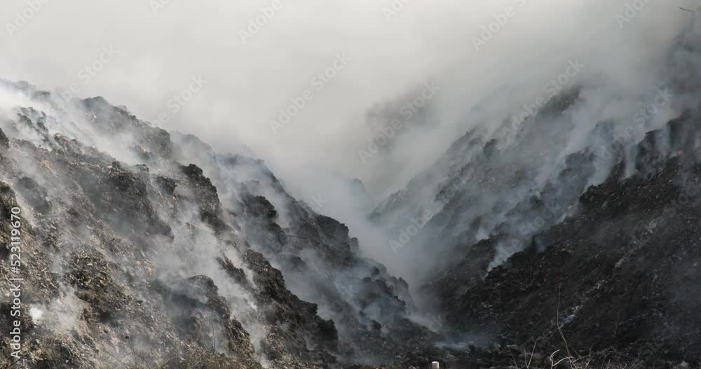 Close up of landfill with burning trash piles Close up of landfill with burning trash piles