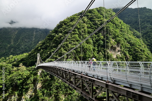 Buluowan Terrace in Taroko National Park - Steep canyon spanned by a footbridge. A modern suspension footbridge spans this steep, densely forested gorge in a popular hiking area. photo