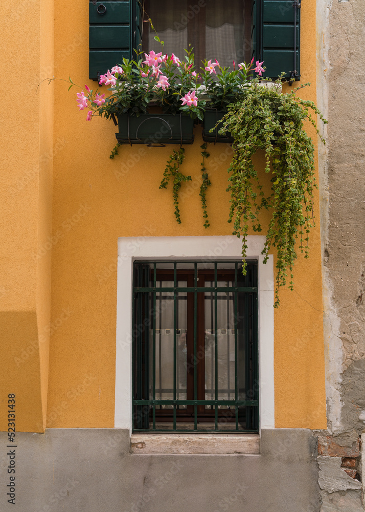 yellow facade with windows and flowers in Venice, Italy