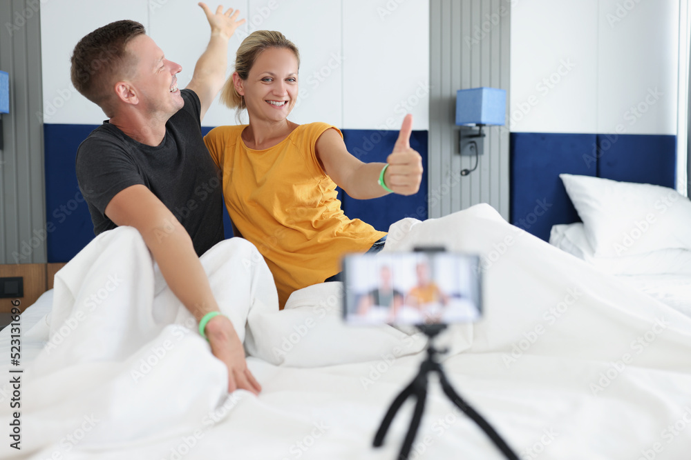 Cheerful couple making photos in hotel room in bad Cheerful couple making photos in hotel room in bad