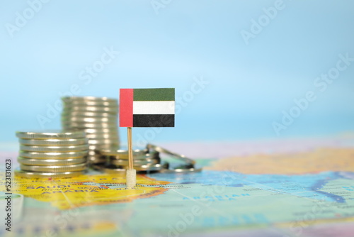 Obraz na płótnie Selective focus of UAE flag in blurry world map with coins. UAE economy and wealth concept. w salonie