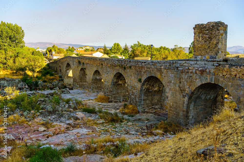 Medieval stone bridge that crosses the dry river in a summer season with great drought and lack of rain, Puente Congosto, Spain.