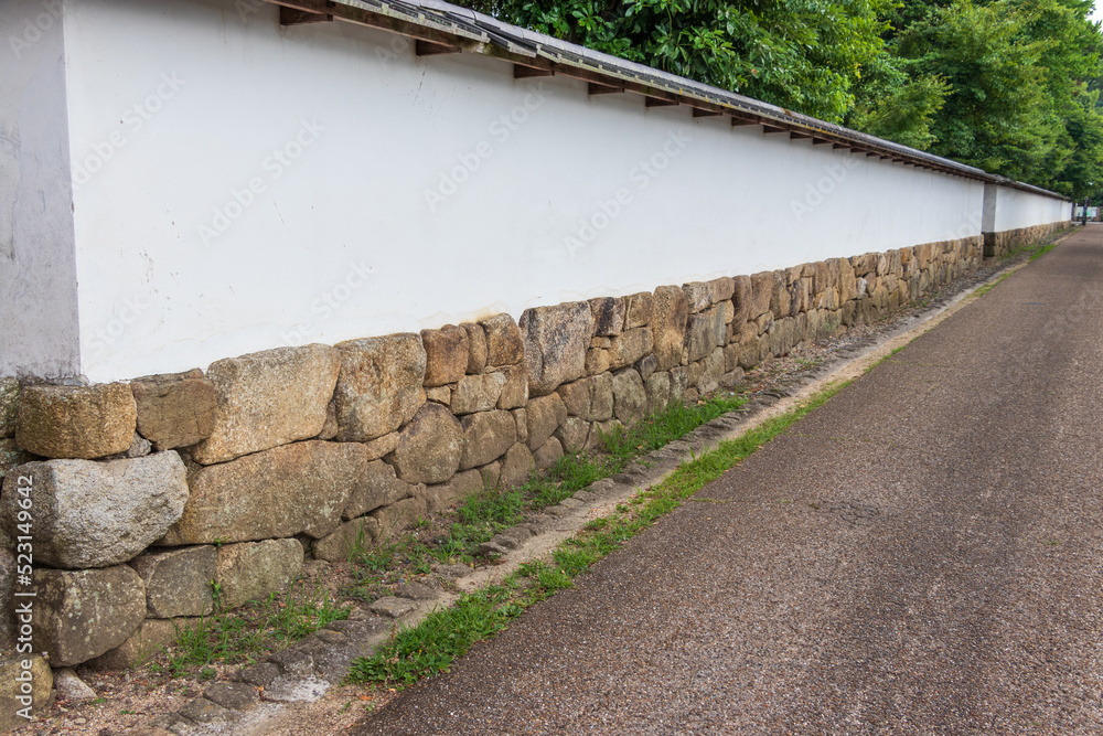 道に沿って続く古い屋敷の白い塀